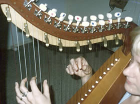 holding left hand on the harp